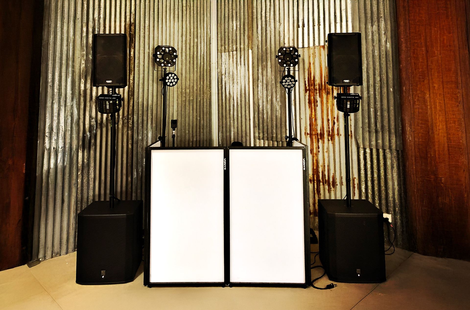 Professional DJ equipment and speaker setup against corrugated iron wall at Melbourne wedding