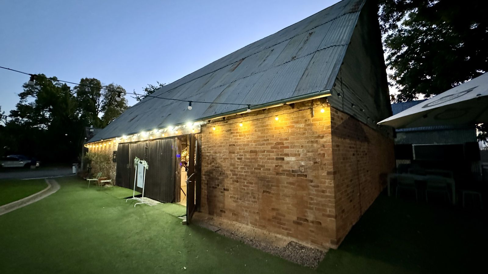 Brick country venue exterior lit for an evening reception
