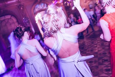 Bridesmaids dancing together at a colourful reception