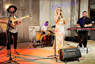 Live band performing for guests in an industrial shed venue