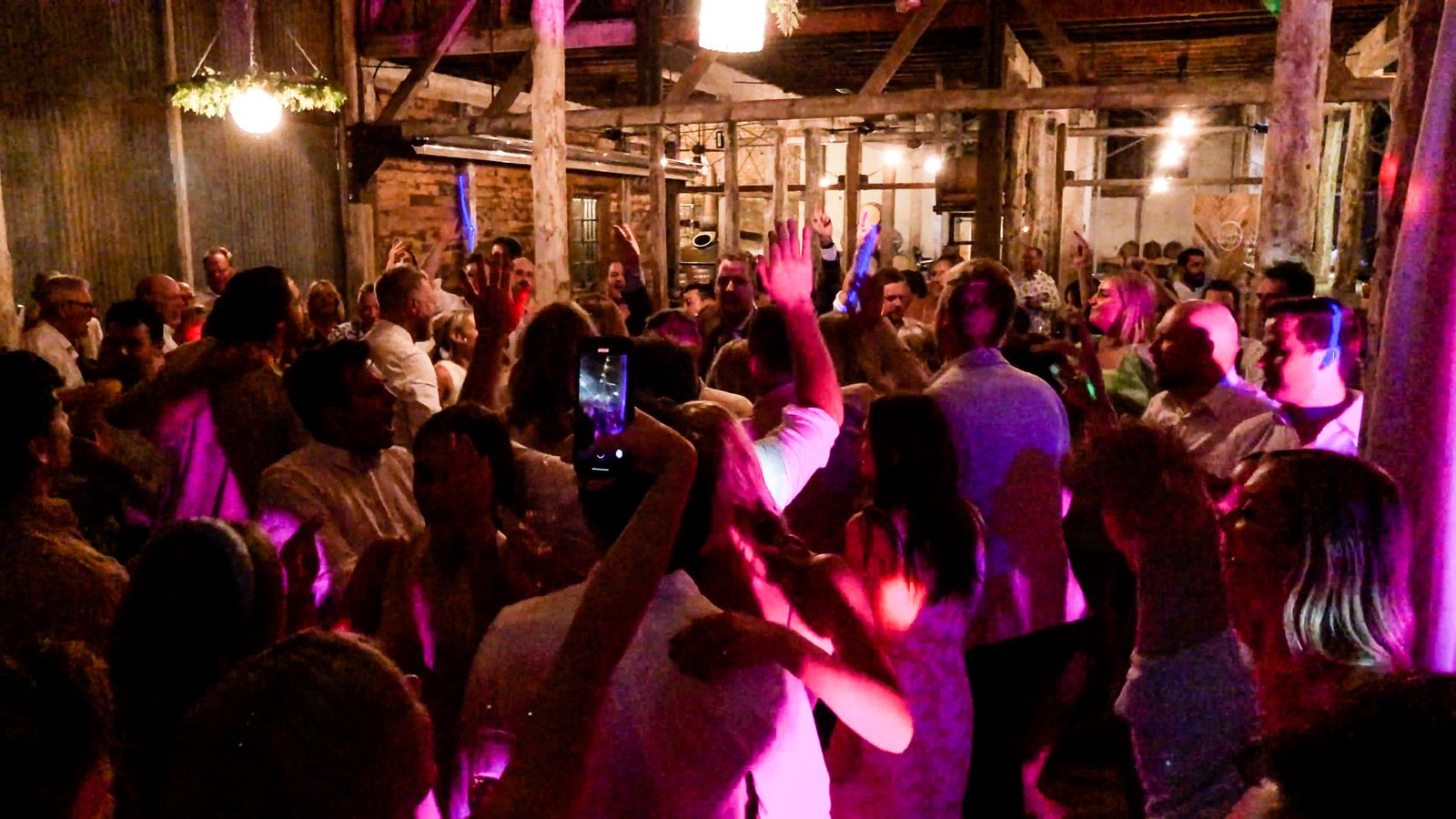 Packed party crowd dancing under warm lights
