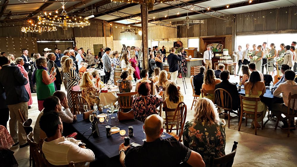 Guests seated for an outdoor ceremony at a rustic venue