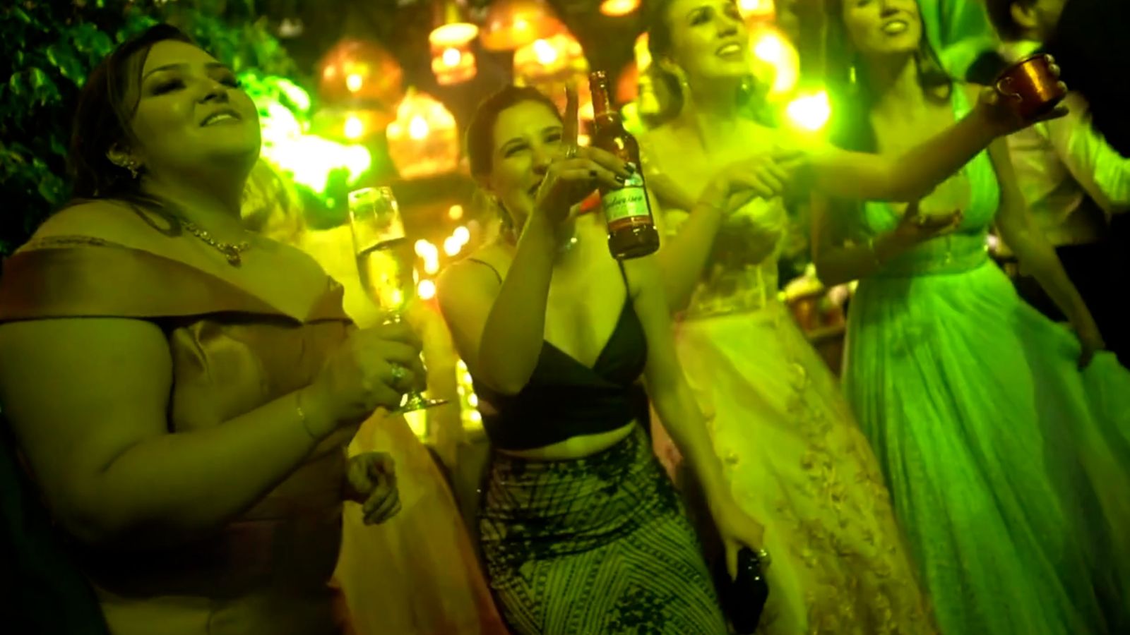 Guests dancing under green festoon lighting