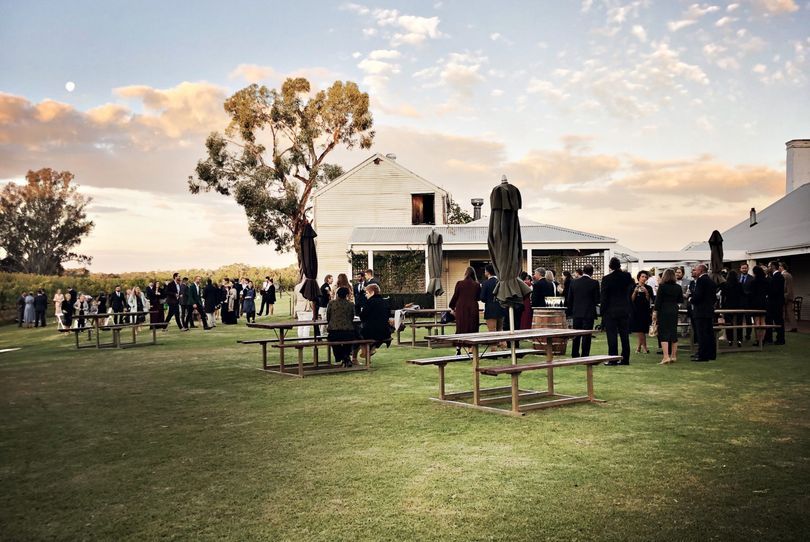 Country wedding venue lawn with guests gathered at sunset