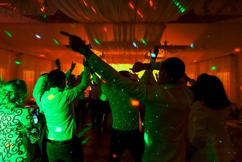 Dancefloor lit by disco lights at a marquee reception