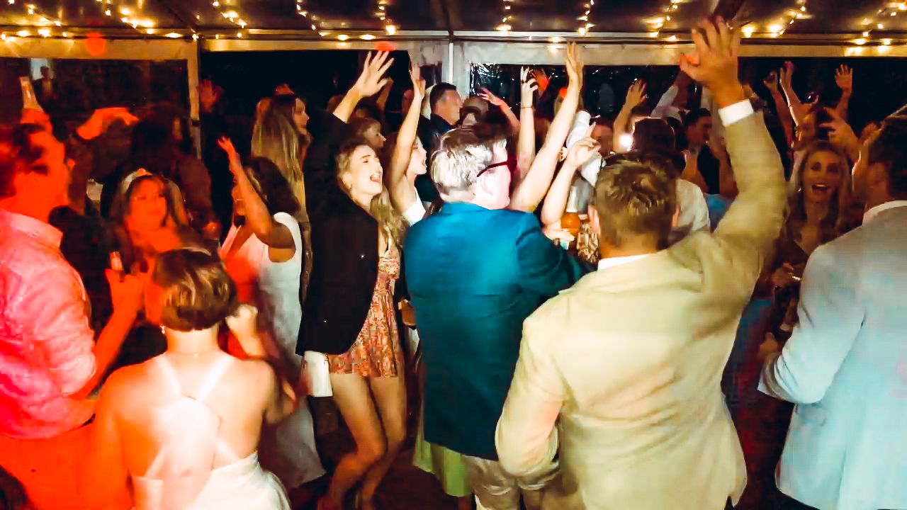 Guests packing the dancefloor under colourful party lights