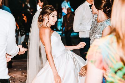Bride dancing with guests at a colourful outdoor reception