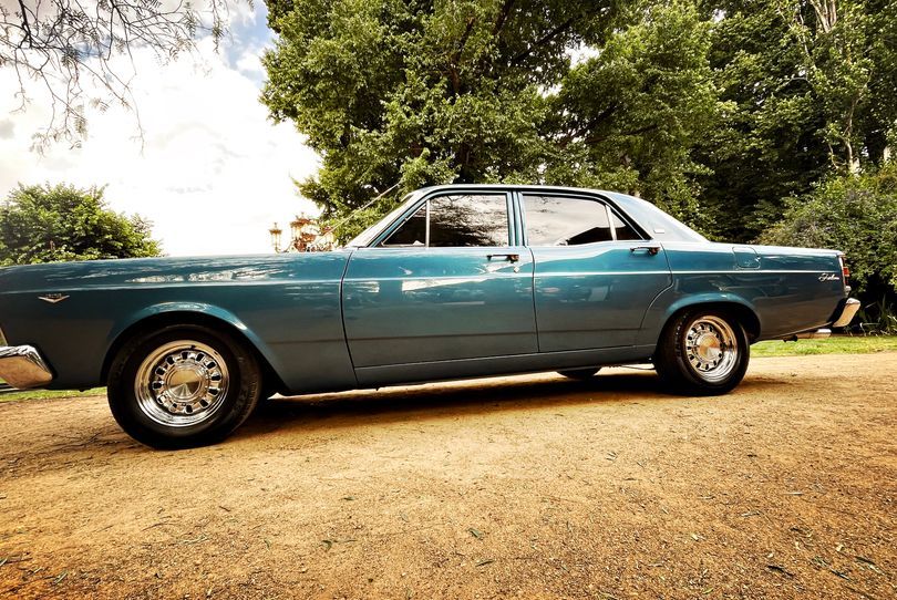 Classic blue wedding car parked at a country venue